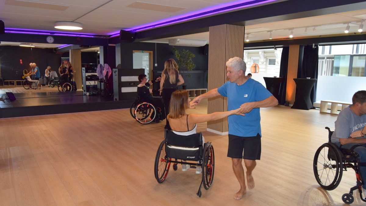 Cours de cyclodanse au Studio 28, Bruxelles : une danseuse en fauteuil roulant tourne avec son partenaire.